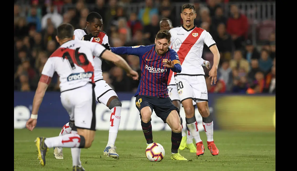 Pemain Barcelona, Lionel Messi (tengah), berusaha melewati hadangan pemain Rayo Vallecano, Jordi Amat (kiri), dalam pertandingan lanjutan La Liga 2018/2019 yang berlangsung di Camp Nou stadium, Sabtu (9/3/2019). (AFP/Lluis Gene)