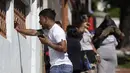 Seorang pria menangis ketika dia berbicara di telepon selulernya di luar Rumah Sakit Getulio Vargas di mana orang-orang menunggu kedatangan mereka yang terluka atau terbunuh dalam penggerebekan di favela Vila Cruzeiro di Rio de Janeiro, Brasil, Selasa (24/5/2022). (AP Photo/Bruna Prado)