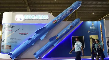 Pengunjung berjalan melewati model rudal jelajah supersonik Brahmos India yang dipamerkan di Defense Expo 2022, Gandhinagar, India, 18 Oktober 2022. Defense Expo 2022 ini akan berlangsung selama lima hari. (Sam PANTHAKY/AFP)
