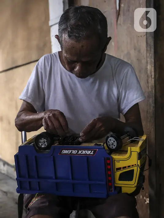 Marsyaad atau biasa dipanggil Pak Umar (79) membuat mobil-mobilan di toko mainan miliknya di Kalibata, Jakarta, Kamis (25/2/2021). Pak Umar yang menjual mainan anak sejak tahun 1974 mengaku tidak terlalu berdampak saat pandemi virus corona COVID-19 berlangsung. (Liputan6.com/Johan Tallo)