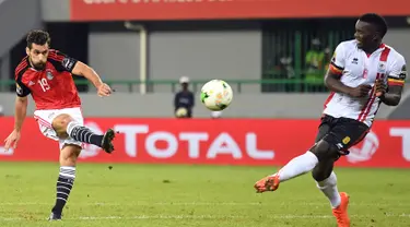 Pemain Mesir, Abdallah Kata (kiri) menendang bola melewati pemain tengah Uganda Khalid Aucho saat Piala Afrika 2017 di Port-Gentil pada 21 Januari 2017. (AFP PHOTO / Justin Tallis)