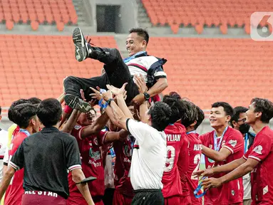 Para pemain Indonesia All Start U-20 mengangkat pelatih Ilham Romadhona saat merayakan kemenangan atas Bali United U-18 pada pertandingan IYC 2021 di Jakarta International Stadium, Jakarta, Selasa (19/4/2022). Indonesia All Stars U-20 menang atas Bali United U-18 2-1. (Liputan6.com/Faizal Fanani)