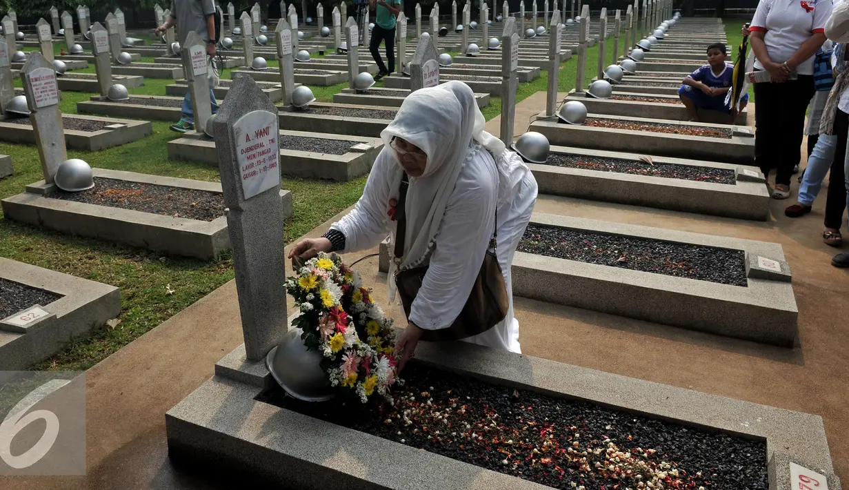 Seorang warga memberikan karangan bunga saat ziarah di TMP Kalibata, Jakarta, Minggu (1/11/2015). Mereka akan membongkar makam keluarga mereka di TMP jika pemerintah melakukan penggusuran terhadap rumah mereka. (Liputan6.com/Johan Tallo)