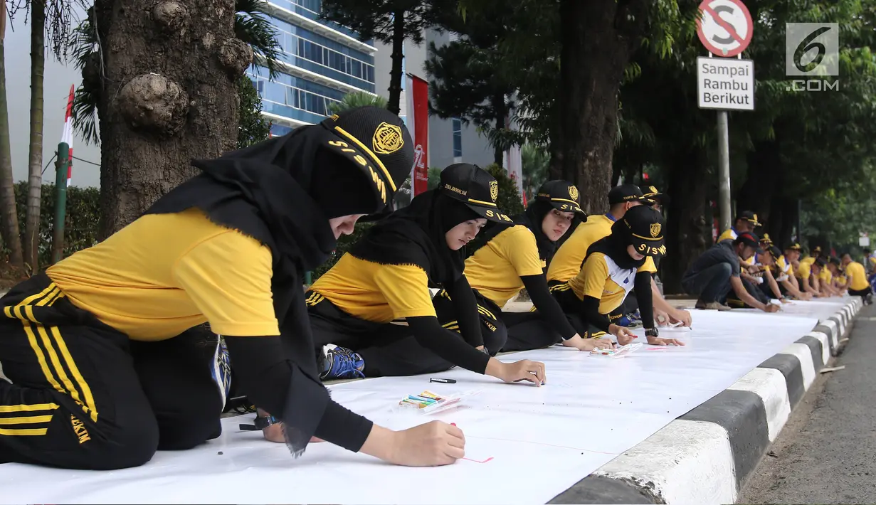 Peserta melukis di atas kanvas selebar 300 meter dalam acara lomba melukis massal di depan Kemenkumham, Jakarta, Minggu (13/8). Kegiatan ini dihadiri 140 murid sekolah dasar dan 320 peserta umum yang berdomisili di Jakarta. (Liputan6.com/Herman Zakharia)
