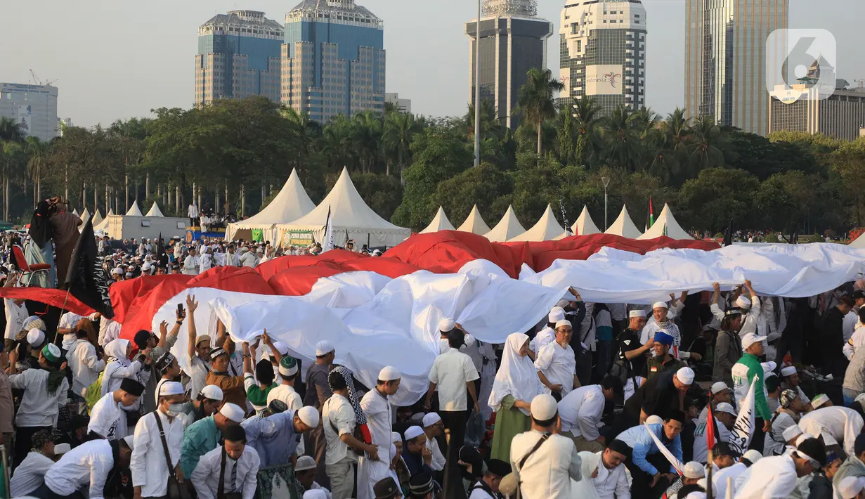 Massa membentangkan bendera Merah Putih saat mengikuti acara Munajat dan Maulid Akbar 2019 #ReuniMujahid212 di kawasan Monas, Jakarta, Senin (2/12/2019). Aksi dimulai dengan salat tahajud bersama pada pukul 03.00 WIB dan ditutup dengan doa yang berakhir pada 08.00 WIB. (Liputan6.com/Herman Zakharia)