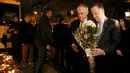 PM Australia Malcolm Turnbull  (kiri) dan PM Selandia Baru John Key menaruh bunga tanda bela sungkawa di salah satu lokasi serangan berdarah Paris di gedung konser Bataclan, Prancis, Minggu (30/11). (REUTERS/Gonzalo Fuentes)