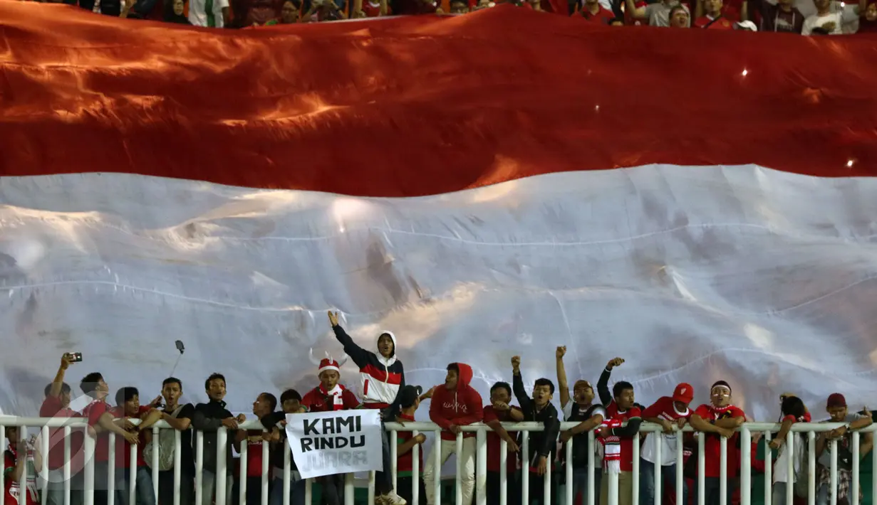 Suporter bersorak di bawah bendera Merah Putih raksasa jelang menyaksikan laga final pertama Piala AFF 2016 antara Indonesia melawan Thailand di Stadion Pakansari, Bogor, Rabu (14/12). Indonesia unggul 2-1 atas Thailand. (Liputan6.com/Helmi Fithriansyah)