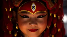 Seorang gadis muda berpakaian seperti dewi Kumari bereaksi terhadap kamera saat menunggu Kumari Puja, sebuah ritual pemujaan di Hanuman Dhoka, Basantapur Durbar Square, Kathmandu, Nepal, Rabu, 27 September 2023. (AP Photo/Niranjan Shrestha)