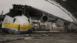 Prajurit Ukraina melewati pesawat Antonov An-225 Mriya yang hancur di bandara Antonov, Hostomel, 2 April 2022. Di pintu masuk Bandara Antonov, pasukan menjaga posisinya, tanda mereka memegang kendali penuh atas landasan pacu yang coba diserbu Rusia di hari-hari pertama perang (AP Photo/Vadim Ghirda)