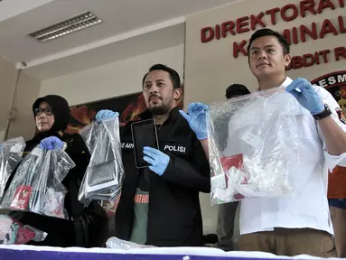 Wadirkrimum Polda Metro Jaya AKBP Ade Ary didampingi staf Humas Kompol Zanariah dan Kanit IV Subdit Resmob Ditreskrimum Polda Metro Jaya AKP Rovan Richard menunjukkan barang bukti kasus prostitusi online, Jakarta, Minggu (6/5). (Merdeka.com/Iqbal Nugroho)