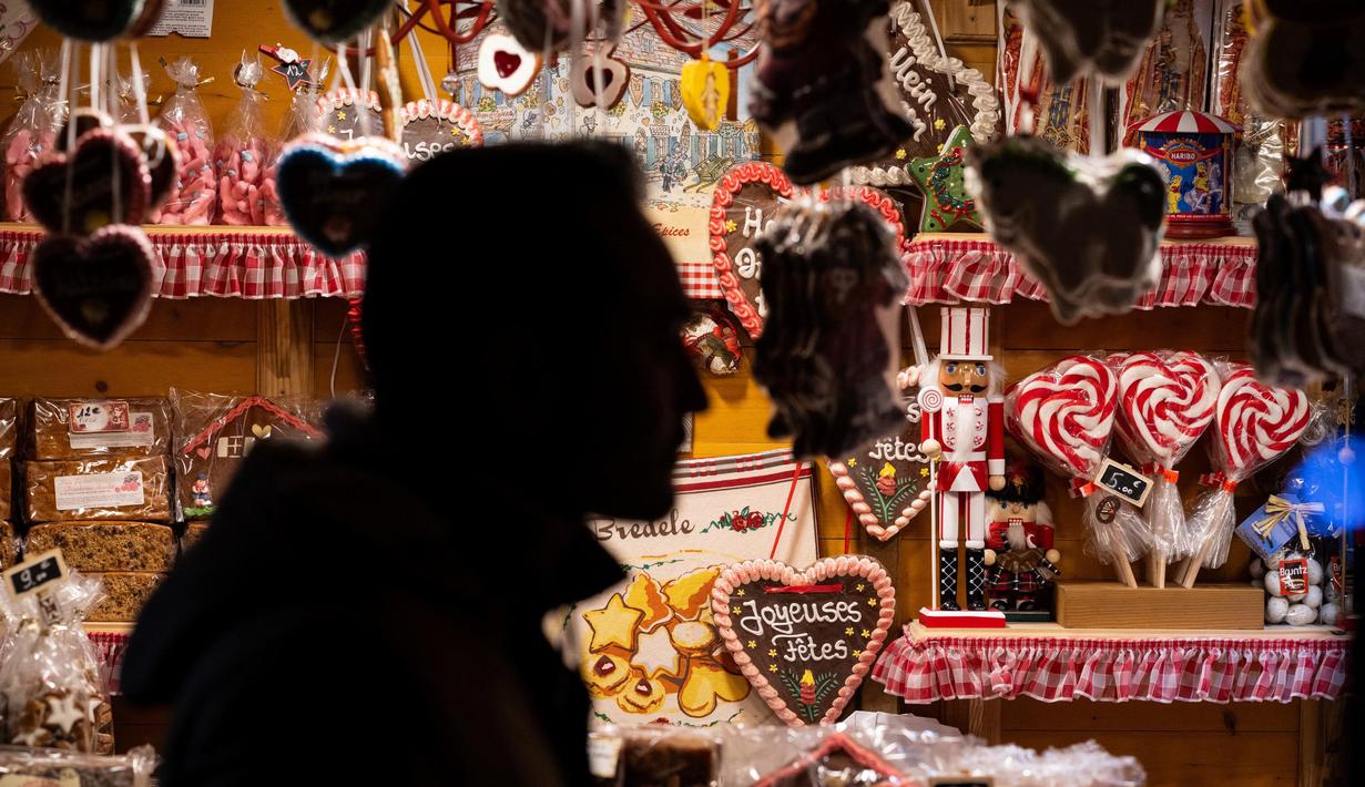 Seorang pria berjalan melewati pasar Natal di Mulhouse, Prancis timur, pada 23 November 2024. (SEBASTIEN BOZON/AFP)