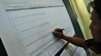 Petugas saat menuliskan hasil suara pasangan calon dari tiap kelurahan(Liputan6.com/Faizal Fanani)
