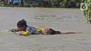 Seorang warga berada berenang saat banjir di Desa Sukalaksana Kabupaten Bekasi, Jawa Barat, Senin (22/02/2021). Banjir tersebut akibat luapan sungai Citarum yang tanggulnya jebol. (Liputan6.com/Herman Zakharia)