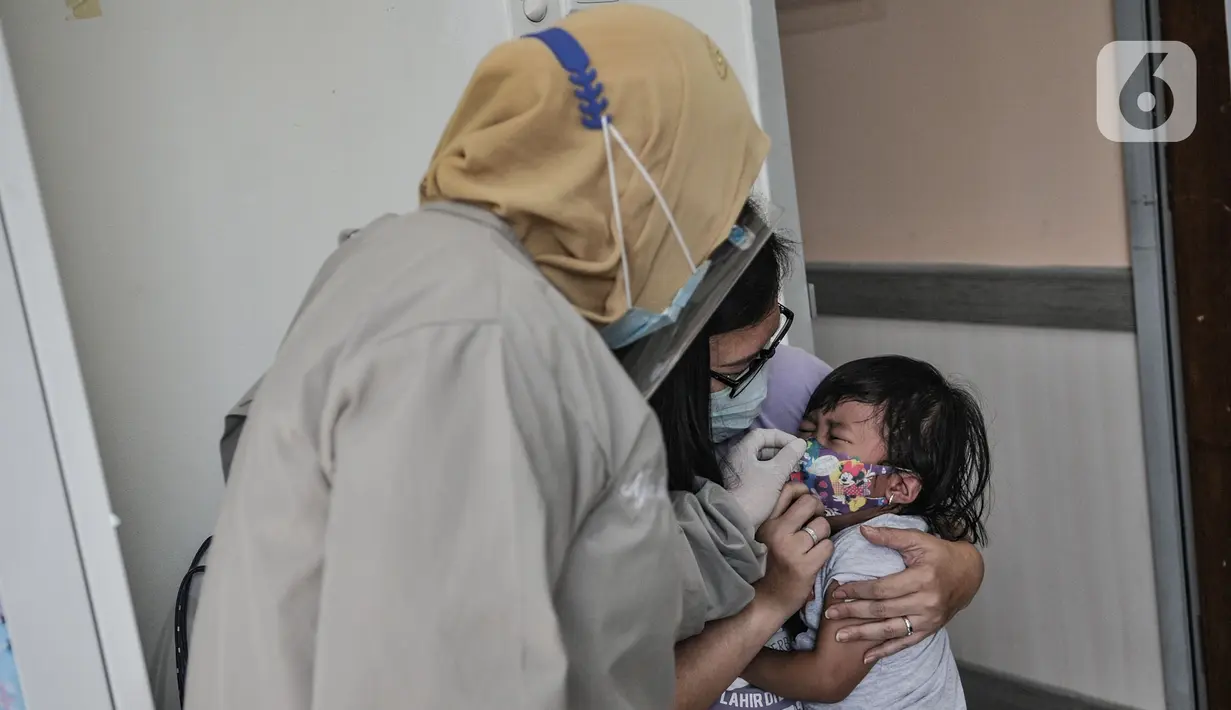 Dokter menenangkan balita usai diberikan imunisasi di Puskesmas Kecamatan Jatinegara, Jakarta, Kamis (26/11/2020). (merdeka.com/Iqbal S. Nugroho)
