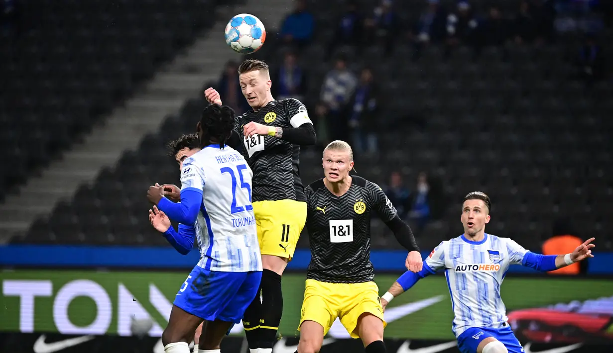 Bek Hertha Berlin Jordan Torunarigha (kiri) berebut bola dengan penyerang Borussia Dortmund Marco Reus pada laga pekan ke-17 Liga Jerman di Olympiastadion, Minggu (19/12/2021) dinihari WIB. Tuan rumah Hertha Berlin mempermalukan Dortmund dengan skor 3-2. (Tobias SCHWARZ / AFP)