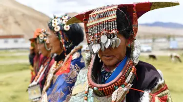 Para perempuan dalam balutan pakaian tradisional Burang terlihat di Wilayah Burang, Prefektur Ali, Daerah Otonom Tibet, China pada 28 Juli 2020. Pakaian tradisional Burang, yang dihiasi dengan emas, perak, mutiara serta perhiasan lainnya, memiliki sejarah lebih dari 1.000 tahun. (Xinhua/Zhan Yan)