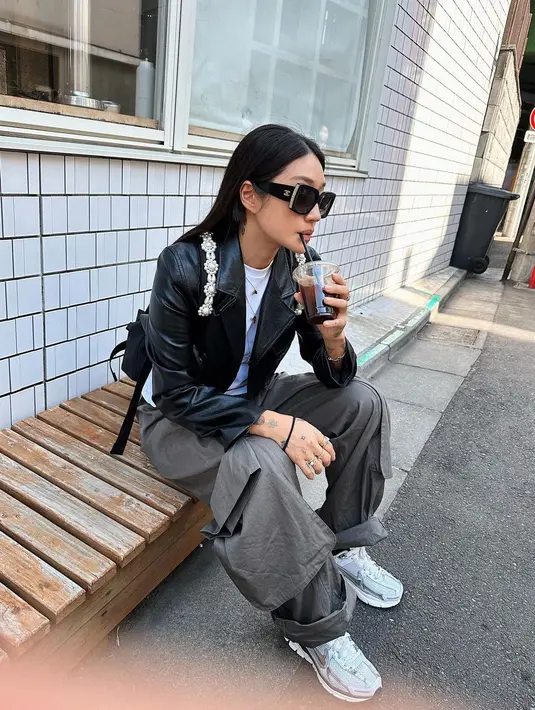 Gaya kasual keren Peggy Gou di foto ini. Ia mengenakan kaus putih, ditumpuknya dengan jaket kulit hitam, dan cargo pants abu-abu. [Foto: Instagram/peggygou_]