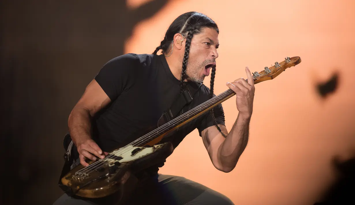 Aksi Basis Metallica, Robert Trujillo saat tampil di Festival d'ete de Quebec di Quebec City, Kanada (14/7). Ribuan penonton terhibur dengan aksi panggung band metal tersebut. (AFP Photo/Alice Chicheby)