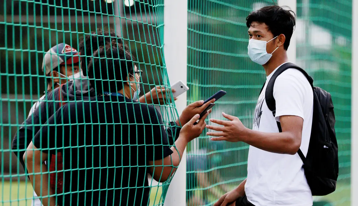 Kiper Timnas Indonesia, Muhammad Riyandi, melakukan wawancara dari balik jaring usai latihan di Lapangan D, Senayan, Jakarta. (Bola.com/ M Iqbal Ichsan)