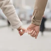 Sepasang kekasih saling memegang jari telunjuk satu sama lain sambil berjalan (Foto Dok: Freepik/freepik).