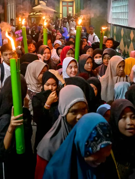 Anak-anak Muslim mengambil bagian dalam pawai obor menjelang bulan Ramadan, di sebuah kawasan pemukiman padat penduduk, Jakarta pada 9 Maret 2024. (Foto oleh Bay ISMOYO / AFP)