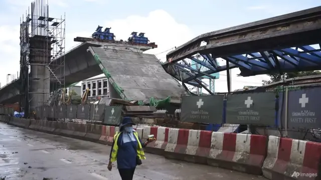 Seorang pekerja melewati jalan layang yang runtuh di Bangkok, Selasa, 11 Juli 2023. (AP/Thanchote Thanawikran)