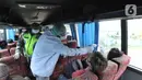 Petugas mengecek suhu tubuh penumpang bus saat penyekatan arus lalu lintas di Ciloto, Cianjur, Jawa Barat, Jumat (17/4/2020). Pemkab Cianjur melakukan pengecekan suhu tubuh dan penyemprotan disinfektan sejumlah titik keluar-masuk Cianjur untuk mencegah penyebaran COVID-19. (merdeka.com/Arie Basuki)