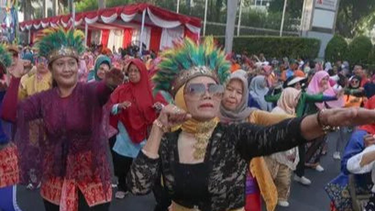Sejumlah perempuan meramaikan 'Gebyar Poco-Poco dan Berkebaya Nasional' selama Hari Bebas Kendaraan Bermotor (atau Car Free Day (CFD) di Bundaran HI, Jakarta, Minggu (14/7/2024). Kegiatan menari poco-poco dalam balutan kebaya ini diadakan untuk menyambut 