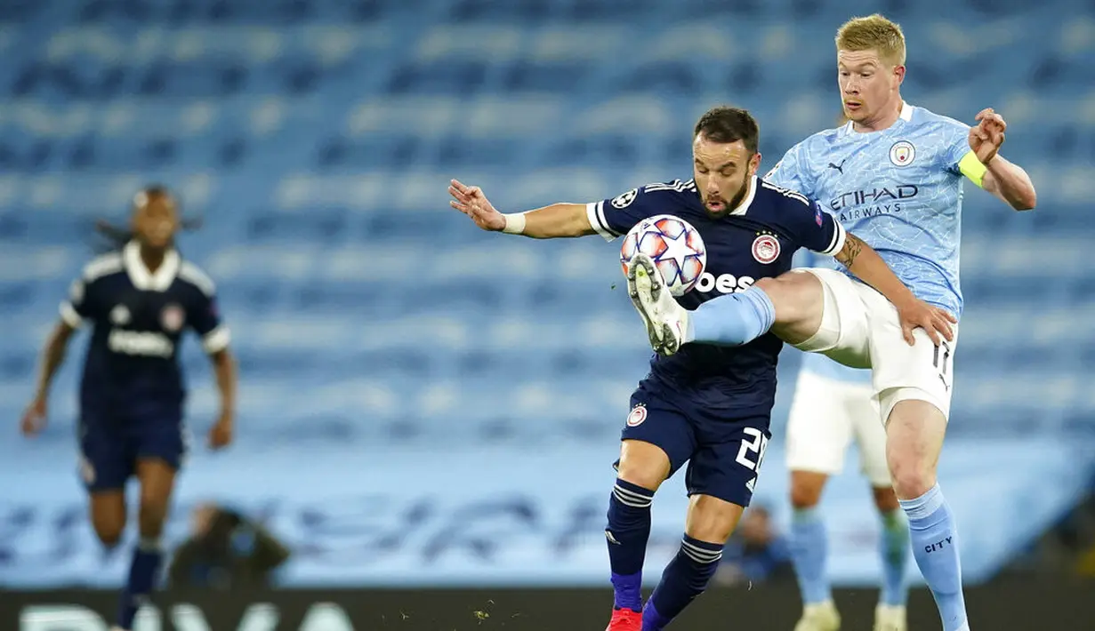 Pemain Manchester City Kevin De Bruyne (kanan) berebut bola dengan pemain Olympiacos Mathieu Valbuena pada pertandingan Grup C Liga Champions di Etihad Stadium di Manchester, Inggris, Selasa (3/11/2020). Manchester City mencukur Olympiacos dengan skor 3-0. (AP Photo/Dave Thompson)