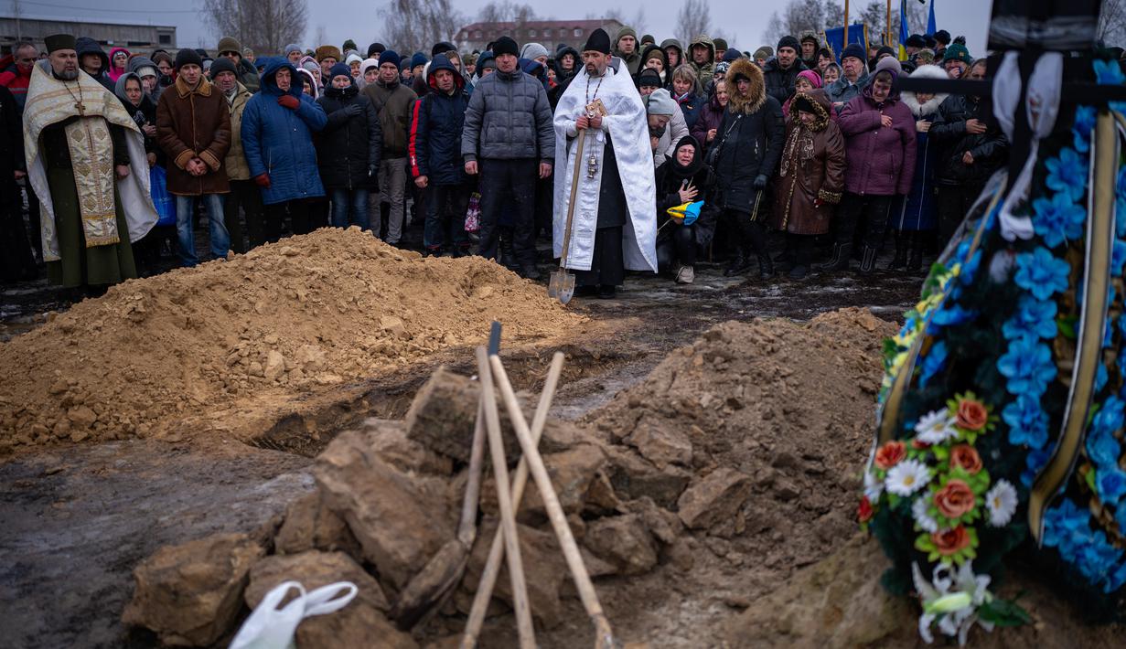 Para pelayat bereaksi di samping jenazah Oleksandr Maksymenko (38) saat pemakamannya di kampung halamannya di Kniazhychi, sebelah timur Kyiv, Ukraina, 13 Februari 2023. Oleksandr Maksymenko, seorang warga sipil yang menjadi sukarelawan di angkatan bersenjata Ukraina, tewas dalam pertempuran di daerah Bakhmut. (AP Photo/Emilio Morenatti)