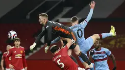 Kiper Manchester United, Dean Henderson memukul bola saat pekan 29 Liga Inggris 2020-2021 kontra West Ham di Old Trafford, Senin dinihari WIB (15/3/2021). Manchester United atau MU berhasil mencuri poin penuh usai kalahkan West Ham 1-0. (AP Photo/Clive Brunskill,Pool)