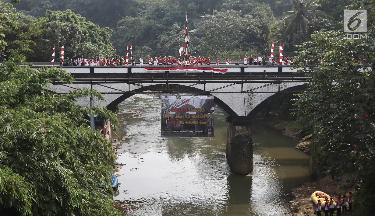 Upacara pengibaran bendera Merah Putih pada peringatan HUT Kemerdekaan RI di Jembatan Panus, Depok, Kamis (17/8). Komunitas Ciliwung Depok melakukan pengibaran bendera di Jembatan Panus yang melintang di atas Sungai Ciliwung (Liputan6.com/Herman Zakharia)
