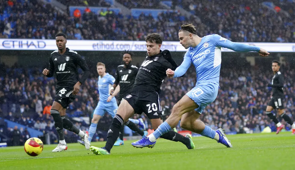Pemain Manchester City Jack Grealish (kanan) mencoba melepaskan tembakan ke gawang melewati pemain Fulham Neco Williams pada pertandingan sepak bola putaran keempat Piala FA di Etihad Stadium, Manchester, Inggris, 5 Februari 2022. Manchester City menang 4-1. (AP Photo/Jon Super)