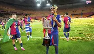 Bintang Barcelona, Lamine Yamal, berpose dengan trofi juara Copa del Rey setelah timnya mengalahkan Real Madrid dengan skor 3-2 pada laga final yang berlangsung Minggu (27/4/2025) dini hari WIB. (AP Photo/Jose Breton)
