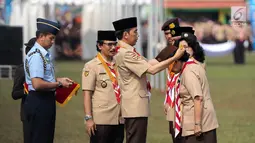 Presiden Joko Widodo memberi penghargaan kepada pramuka berprestasi saat acara Peringatan Hari Pramuka dan Pembukaan Raimuna Nasional XI Gerakan Pramuka di Bumi Perkemahan Cibubur, Jakarta, Senin (13/8). (Liputan6.com/Faizal Fanani)