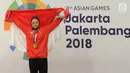 Pesilat Indonesia Sarah Tria Monita mengangkat bendera Merah Putih usai menaklukkan Nong Oy Vongphakdy asal Laos dalam babak final Kelas C Putri Asian Games 2018 di Jakarta, Senin (27/8). Sarah menang dan mendapatkan medali emas. (Merdeka.com/Arie Basuki)