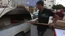 Penjual roti Palestina Mohammed Abu Saud menyiapkan roti di Kota Nablus, Tepi Barat, (3/5/2020). Abu Saud, yang kehilangan pekerjaannya sebagai pekerja transportasi karena kebijakan lockdown selama pandemi COVID-19, memutuskan bekerja sebagai penjual roti keliling. (Xinhua/Ayman Nobani)