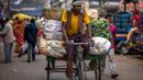 Seorang pria dengan sepeda roda tiga mengangkut sayuran di sebuah pasar grosir di Guwahati, India, Rabu (1/2/2023). Pemerintah Perdana Menteri India Narendra Modi meningkatkan belanja modal sebesar 33% untuk memacu pertumbuhan ekonomi dan menciptakan lapangan kerja menjelang pemilihan umum tahun depan. (AP Photo/Anupam Nath)