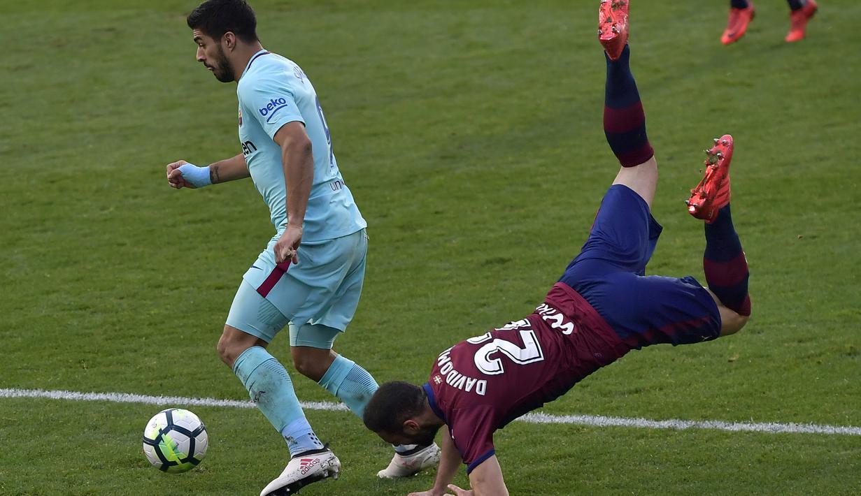 Aksi pemain FC Barcelona, Luis Suarez (kiri) melewati adangan pemain SD Eibar, David Lomban pada lanjutan La Liga Santander di Ipurua stadium,  Eibar, (17/2/2018). Barcelona menang 2-0. (AP/Alvaro Barrientos)