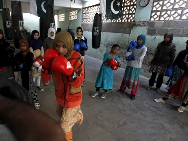 Seorang gadis Pakistan bernama Anum saat berlatih bersama pelatih tinjunya di kamp tinju wanita, Karachi , Pakistan, (20/2). Tempat latihan tinju khusus wanita ini adalah yang pertama yang ada di Pakistan. (REUTERS / Akhtar Soomro)