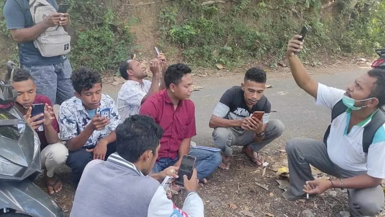Warga, perangkat desa dan pendamping desa sedang mencari sinyal di daerah yang bisa masuk jaringan internet. (Liputan6.com/ Dionisius Wilibardus)