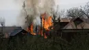 Sejumlah bangunan tempat tinggal terbakar akibat pertempuran senjata antara kelompok militan dan pasukan keamanan India di Shopian, Srinagar (4/1). (AP Photo / Mukhtar Khan)