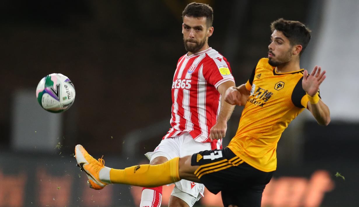 Gelandang Wolves, Pedro Neto, berebut bola dengan bek Stoke City, Tommy Smith, pada laga kompetisi Piala Inggris di Malineaux Stadium, Jumat (18/9/2020) dini hari WIB. Wolves kalah 0-1 oleh Stoke City. (AFP/Catherine Ivill/pool)
