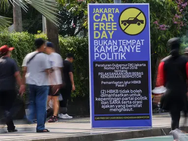 Warga berolahraga di dekat poster peringatan larangan kampanye politik saat Hari Bebas Kendaraan Bermotor atau Car Free Day (CFD) di Kawasan Bundaran HI, Jakarta, Minggu (19/11/2023). (Liputan6.com/Angga Yuniar)
