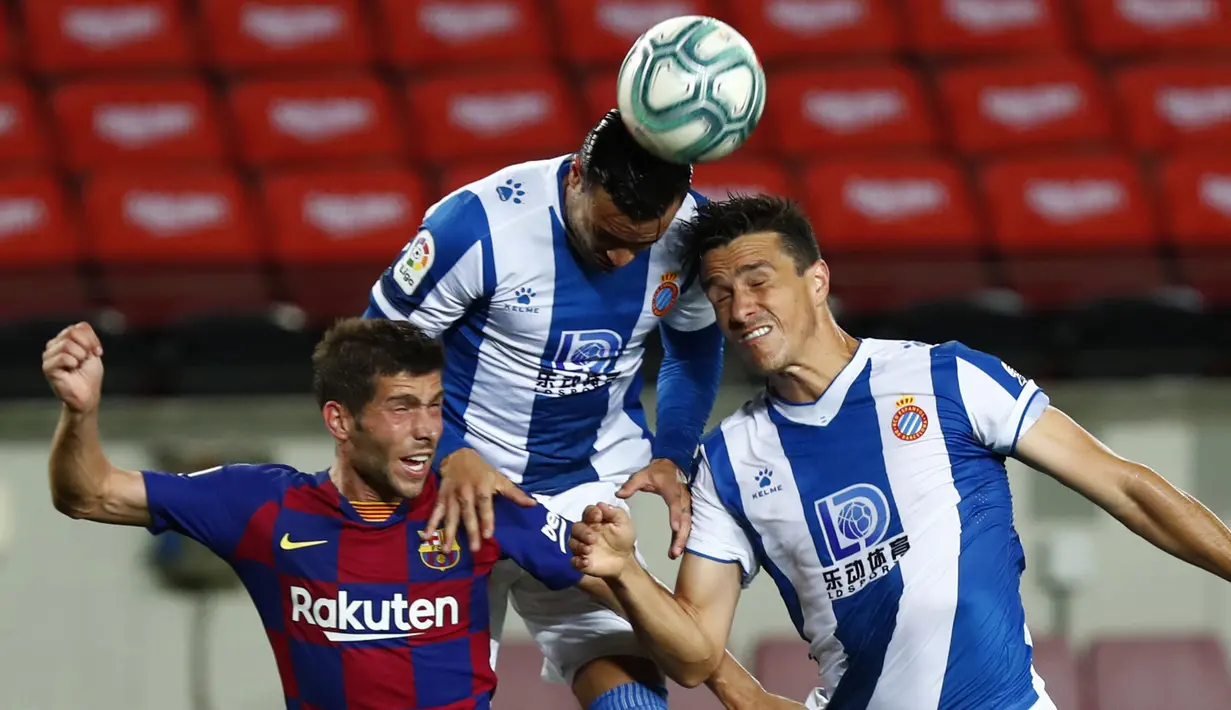 Pemain Barcelona, Sergi Roberto, duel udara dengan pemain Espanyol, Raul De Tomas dan Bernardo Espinosa, pada laga La Liga di Stadion Camp Nou, Rabu (8/7/2020). Barcelona menang 1-0 atas Espanyol. (AP/Joan Monfort)
