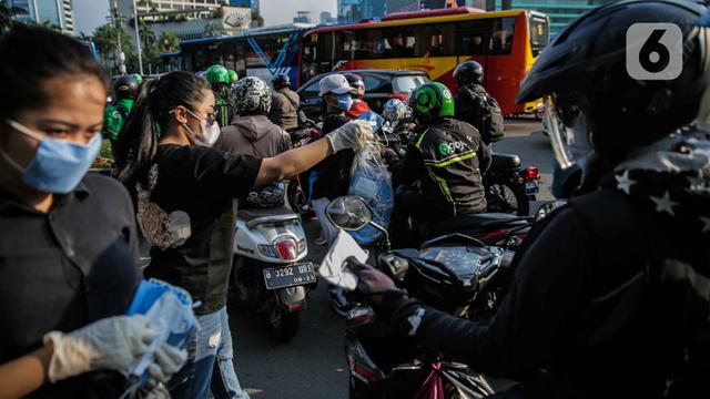 Relawan Bagi-Bagi Masker ke Pengguna Jalan