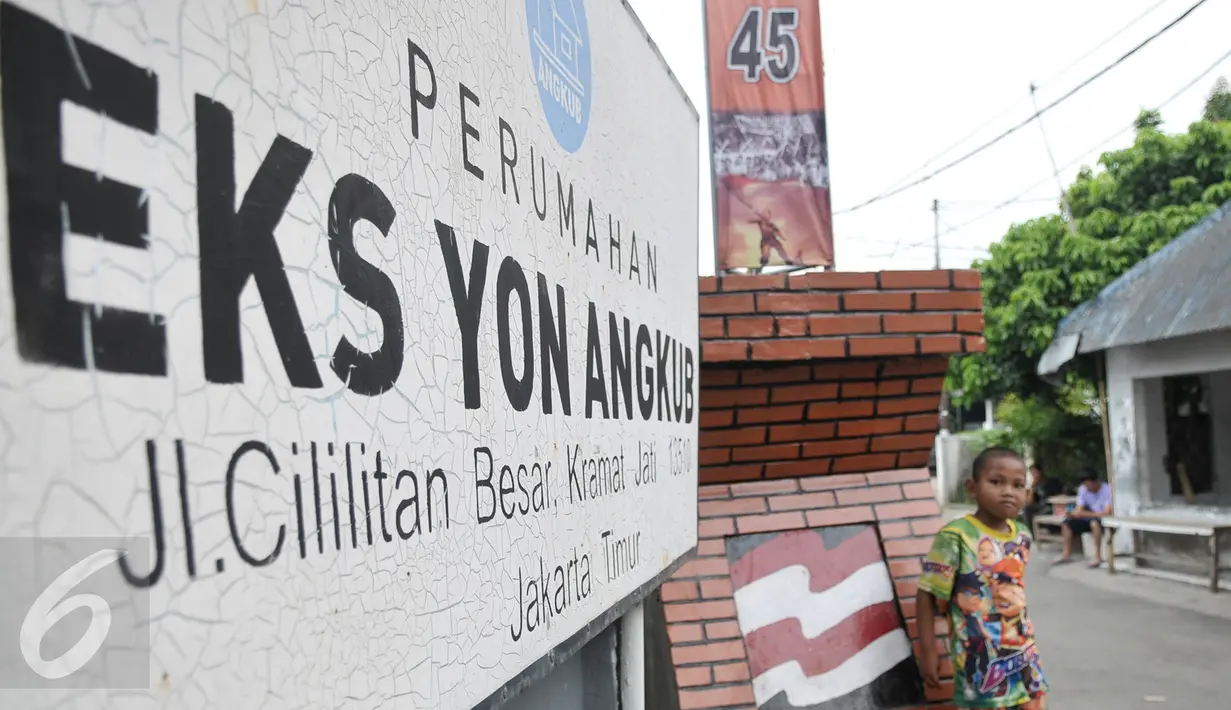 Seorang anak berdiri di dekat plang perumahan Eks Yon Angkub, Cililitan Besar, Jakarta, Rabu (14/9). Warga di kawasan perumahan itu menolak eksekusi rumah yang akan dilakukan oleh Kodam Jaya. (Liputan6.com/Yoppy Renato)