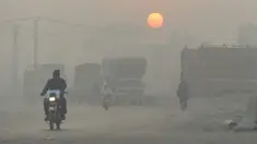 Pengendara kendaraan melintas di tengah kondisi kabut asap di Lahore, Pakistan, Senin (8/11/2021). Lahore menjadi salah satu kota paling tercemar di dunia. (Arif ALI/AFP)