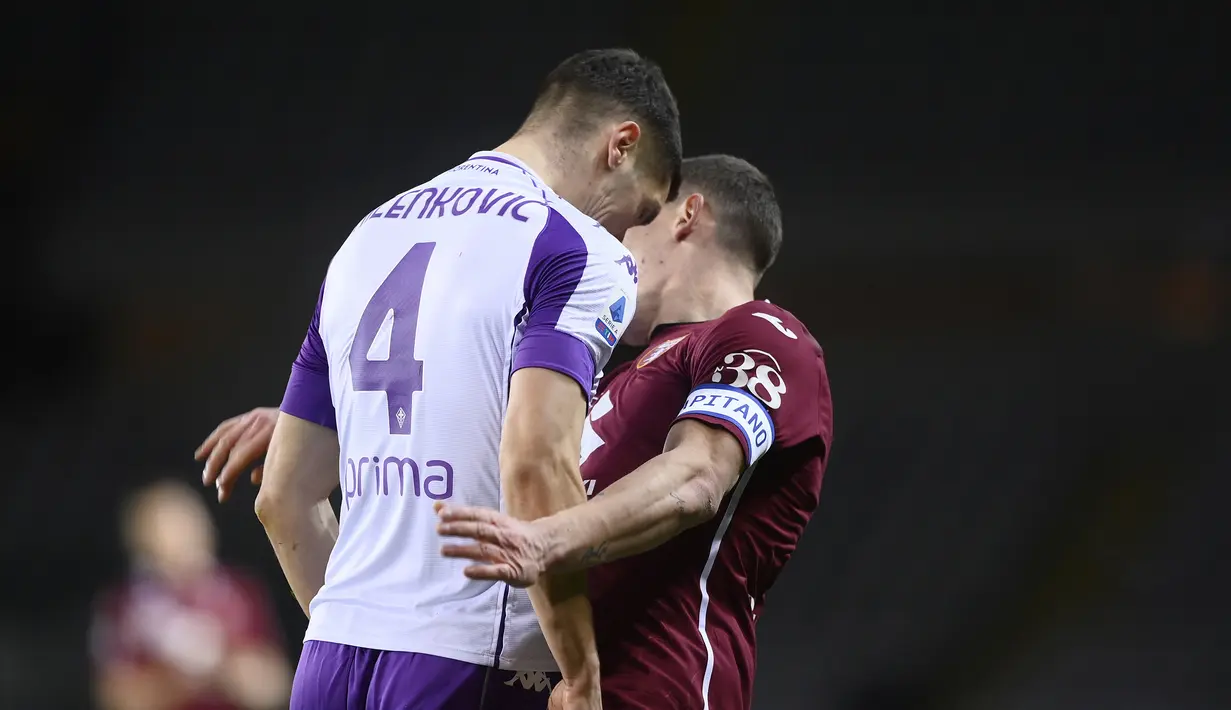 Bek Fiorentina, Nikola Milenkovic (kiri) menanduk striker Torino, Andrea Belotti dalam laga lanjutan Liga Italia 2020/21 pekan ke-20 di Olympico Grande Stadium, Jumat (29/1/2021). Fiorentina bermain imbang 1-1 dengan Torino. (LaPresse via AP/Fabio Ferrari)