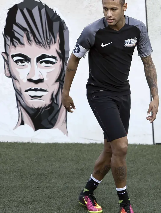 Neymar saat melintasi mural gambar dirinya pada laga sepak bola mini yang merupakan bagian dari  Neymar Junior Institute project di  Praia Grande, Sao Paulo, Brasil, (9/7/2016). (AFP/Miguel Schincariol)